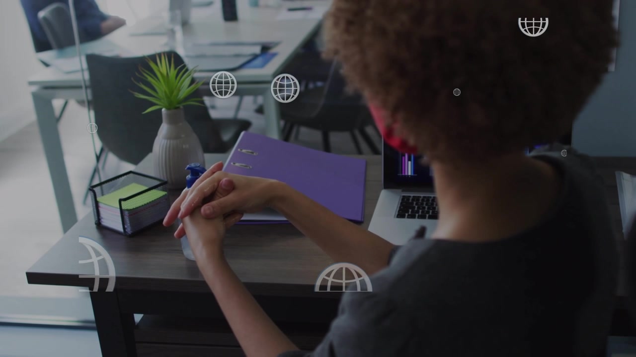 Woman Applying Hand Sanitizer at Her Office Desk