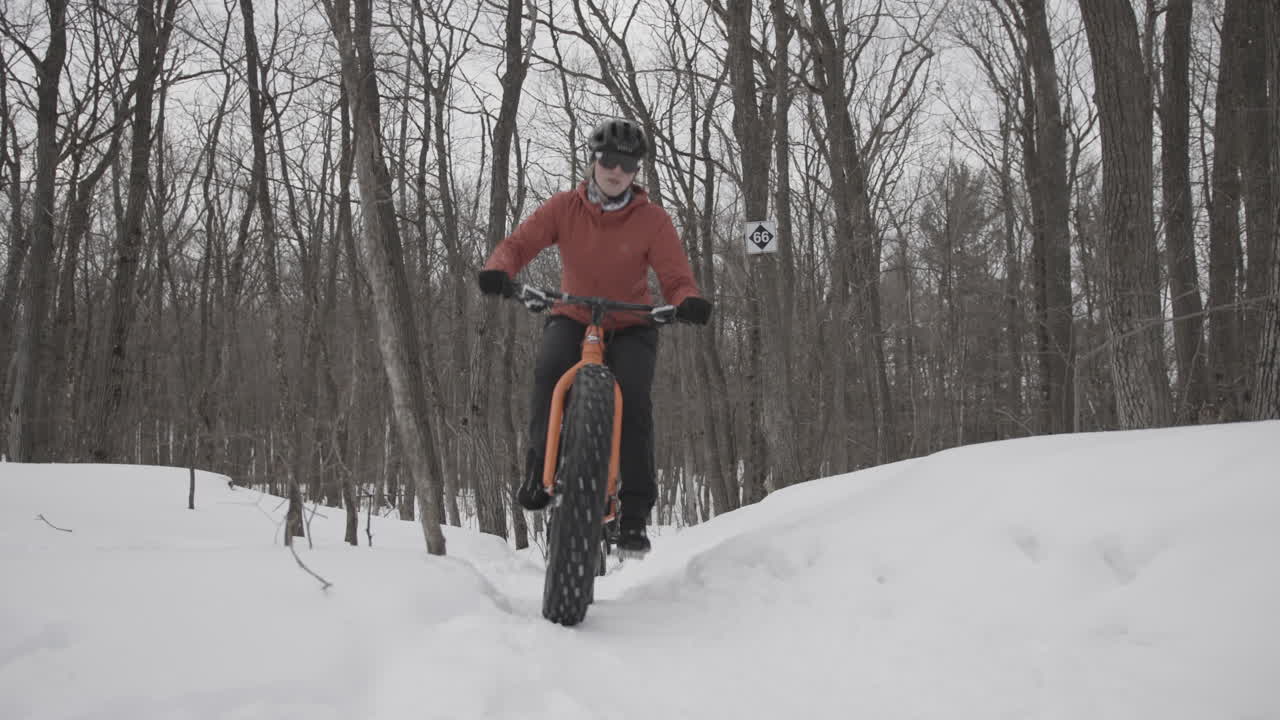 Female Cyclists pedalling fat bikes on winter trail