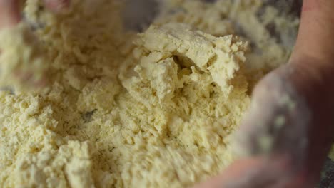 a person mixes dough with their hands