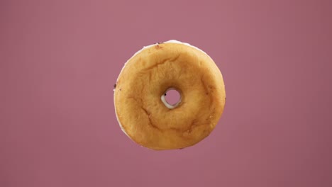 rosquilla con fondo rosado. postre dulce volador. concepto de panadería y comida