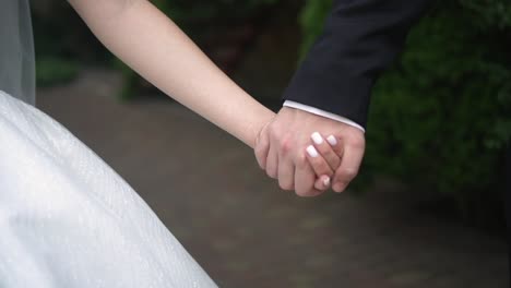 the bride and groom hold hands