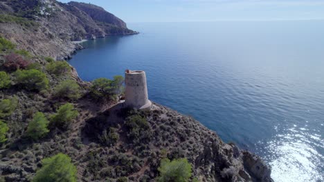 medieval watchtower next to cliffs on the mediterranean coast