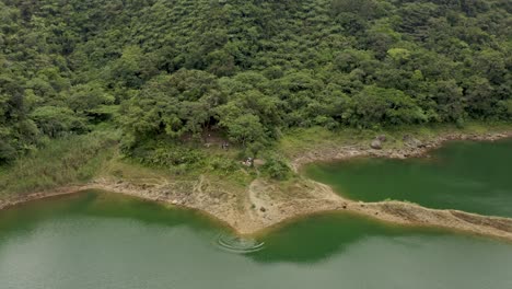 Group-Of-Tourists-Enjoying-The-Hiking-In-Beautiful-Danao-Lake-In-Ormoc,-Leyte,-Philippines---Aerial-Shot-Pull-back