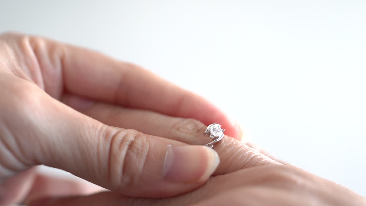 cerrar la mano de la mujer sosteniendo un anillo, llevar a otra mano