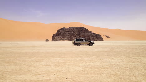 4x4 car driving on speed at a desert in djanet sand dune on a sunny day in algeria