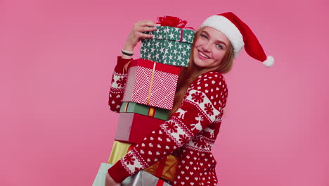 Woman-in-Christmas-red-sweater,-Santa-hat-smiling-holding-many-gift-boxes-New-Year-presents-shopping