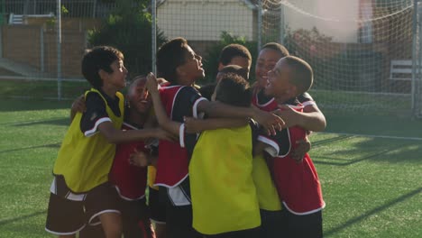 soccer kids hugging and laughing in a sunny day