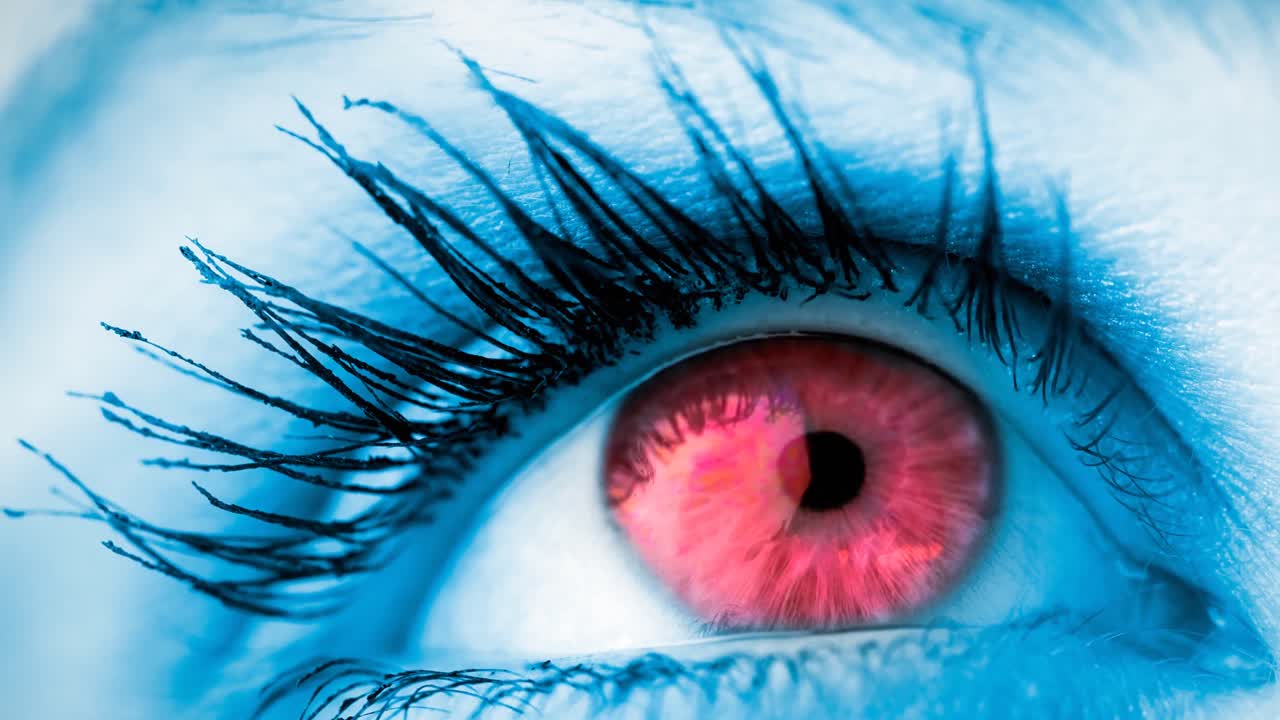 primer plano de un ojo rojo femenino contra un fondo azul