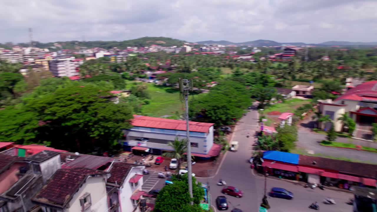 Mobile signal tower with trees, road, vehicles, and roof top buildings at goa, india. day time, orbit shot, drone shot, 4k