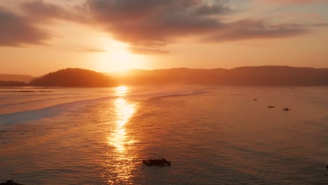 Sunrise-at-the-surf-spots-of-Gerupuk-in-Lombok,-with-a-view-on-the-bay-with-the-fishing-boats-and-surfers