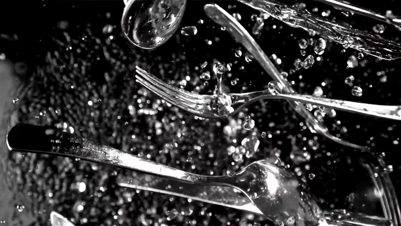 Wasser spritzt in Zeitlupe auf Besteck