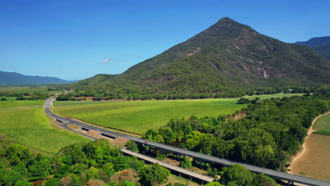 Malerische-Straße-Zwischen-Grünen-Feldern-Und-Bergen-In-Cairns,-Queensland,-Australien---Luftdrohnenaufnahme