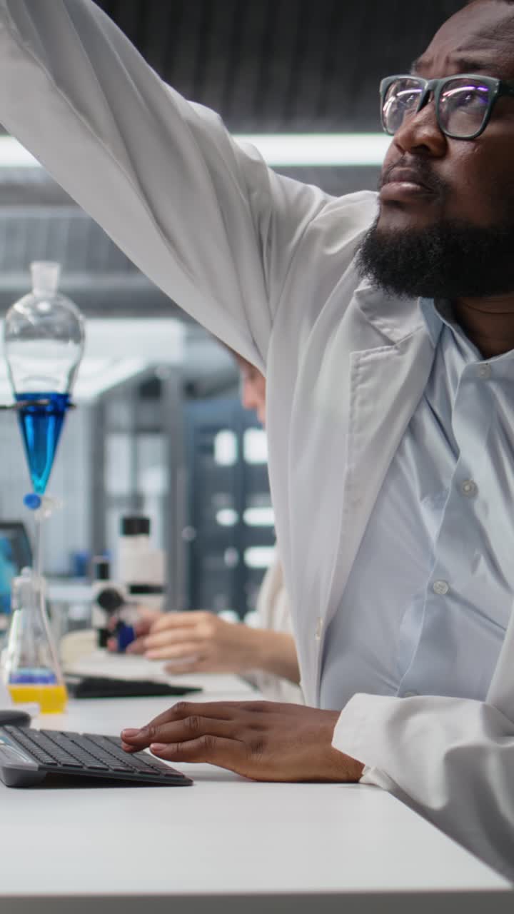 Vertical video Scientist in laboratory interprets clinical blood values on computer