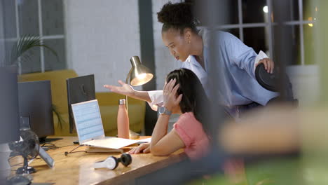 young african american woman assists a biracial woman in a business office setting