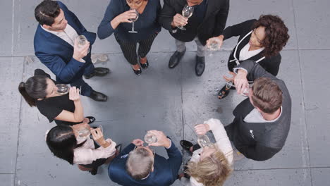 overhead shot of business team celebrating success with champagne toast in modern office