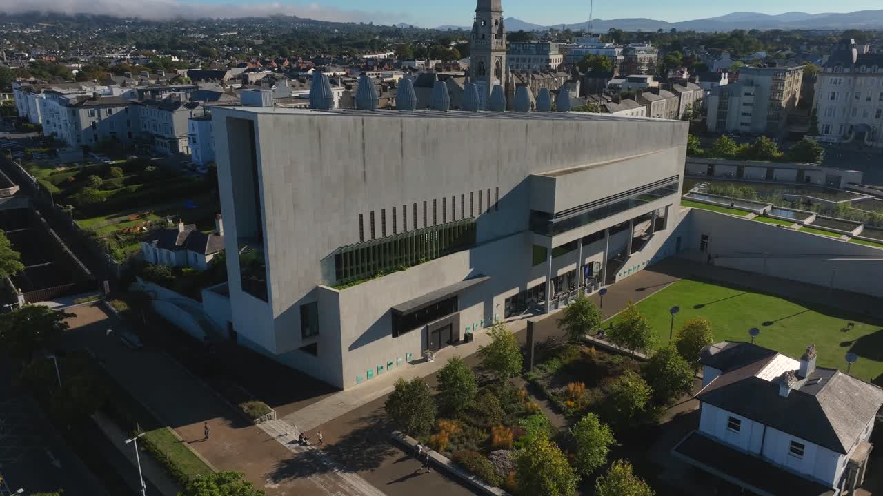 LexIcon, Dún Laoghaire, County Dublin, Ireland, September 2024. Drone orbits clockwise showcasing the iconic facade of the Library and Cultural Centre with the Royal Marine Hotel in the background.