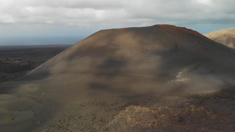 Luftaufnahme-Der-Schatten-Von-Wolken,-Die-Auf-Einem-Vulkanischen-Hügel-Vorbeiziehen