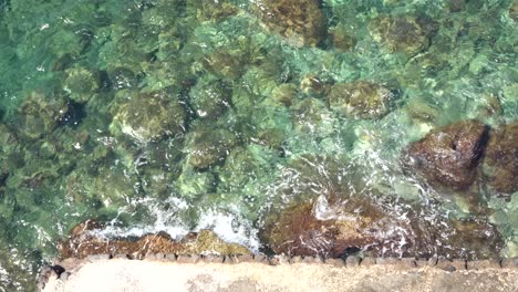 The-water-of-the-Mediterranean-Sea-smashing-on-the-rocks-in-Ischia-Forio,-Naples,-Italy