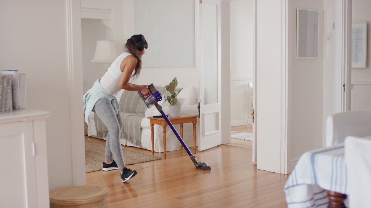 adolescente feliz bailando con la aspiradora haciendo tareas limpiando la casa divirtiéndose baile tonto escuchando música usando auriculares disfrutando de una mañana de fin de semana despreocupada en casa 4k
