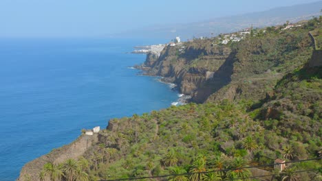 experience the stunning cliffs and coastline of tenerife in the canary islands. witness the vibrant blue atlantic ocean meeting the lush greenery and dramatic landscapes of this beautiful location.