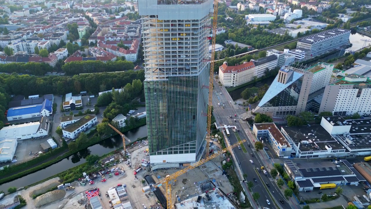 Canteiro de obras da torre Estrel em Berlim 2024, com guindastes e paisagem urbana ao fundo. Melhor vista aérea de drone, de cima para baixo