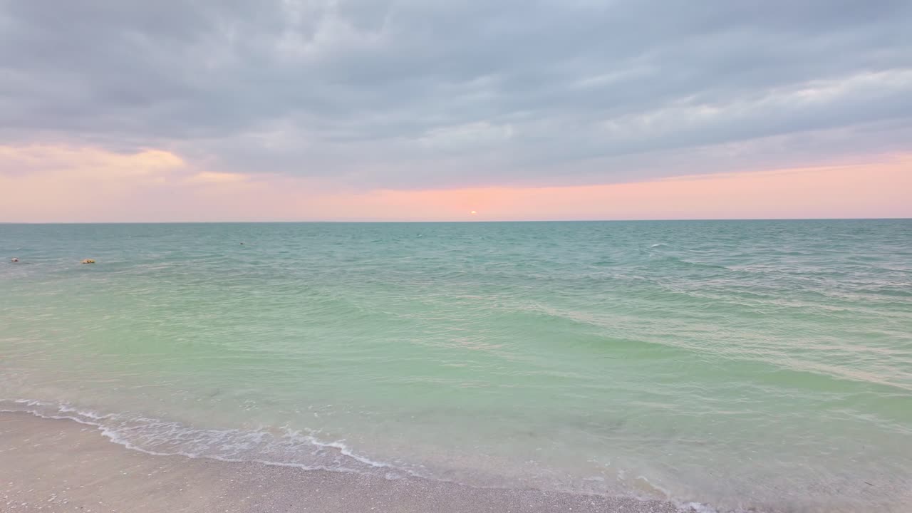 A serene beach scene at Holbox Punta Cocos, Mexico, with soft waves and pastel skies