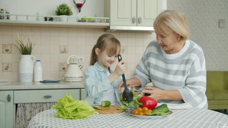 grandmother and granddaughter making salad together