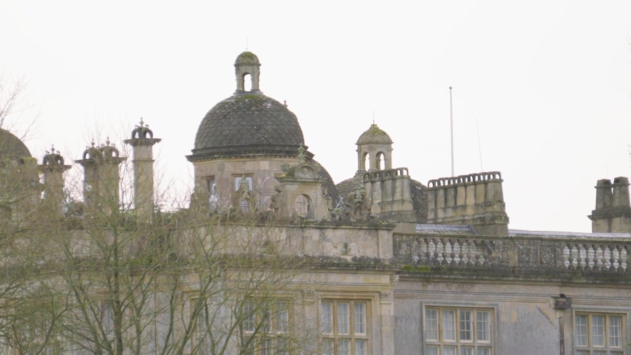 Plano em movimento de um antigo e histórico edifício senhorial britânico construído com rocha calcária.