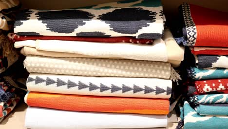 stacked colorful blankets and rugs