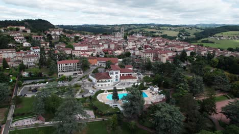 drone shot goinf forward flyng over saint galmier and it's church to reveal the landscape behind, loire departement, region auvergne rhone alpes, france