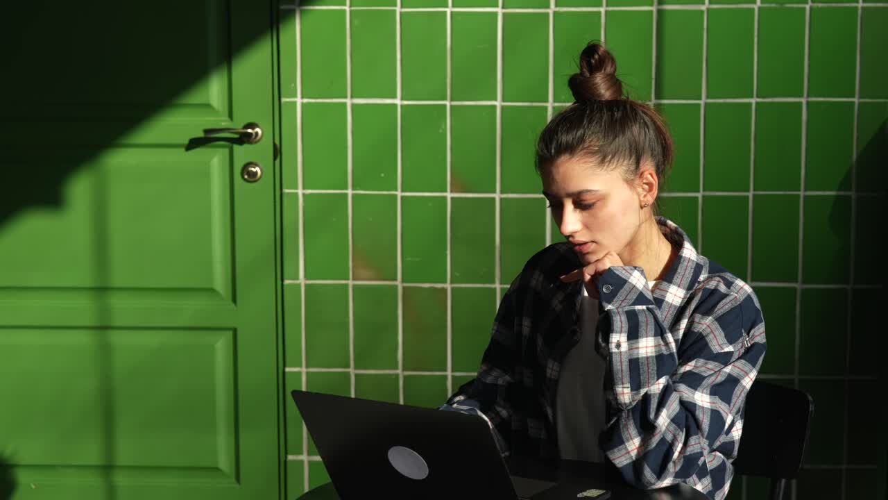 mujer trabajando en una computadora portátil en un café