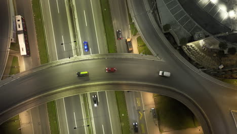aerial night view of a busy highway interchange with moving traffic