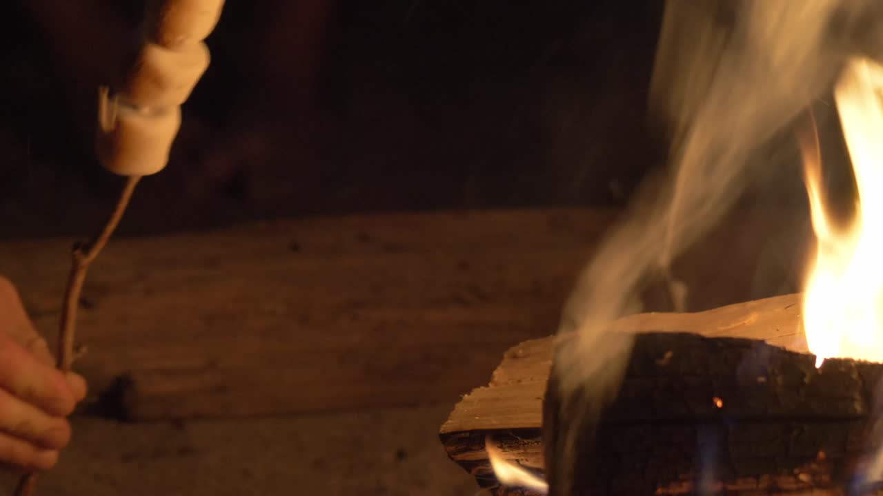 모닥불 옆에서 스틱 쿡에 흰색 마시멜로