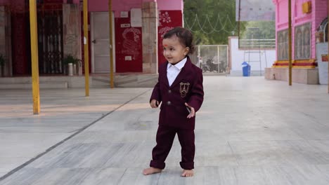 cute indian toddler walking in suit at outdoor from different angle