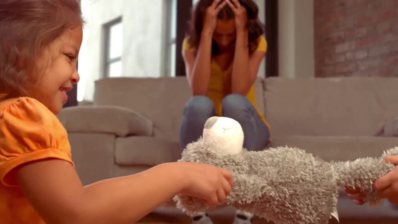 어머니가 머리 위에 손을 고 있는 동안 히스패닉 아이들이 논쟁을 벌이고 있습니다.