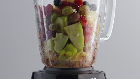 ingredients fruit smoothie blending in mixer bowl super slow motion close up.