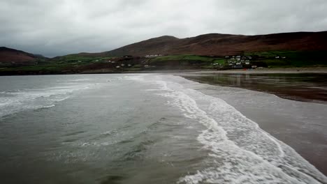 Drone-view-of-a-wide-Irish-beach-with-mountains-behind