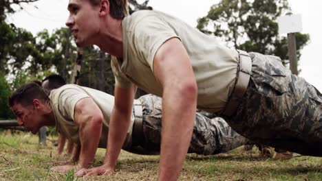 soldados militares haciendo flexiones durante una carrera de obstáculos de 4 km