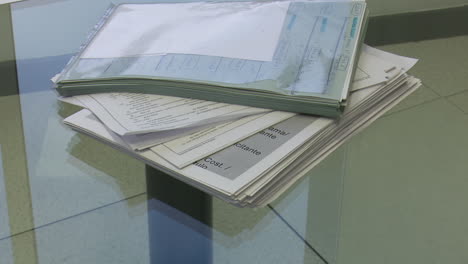 stack of documents on a glass table