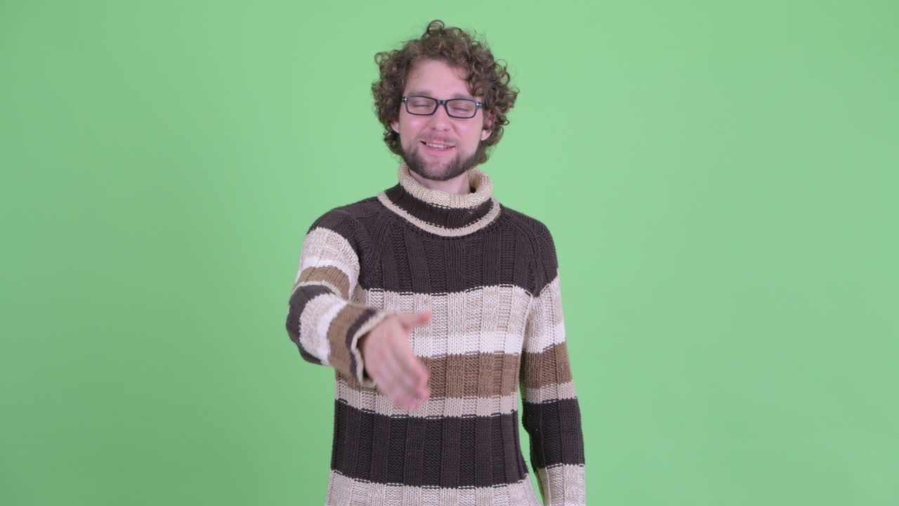 un joven guapo con barba y cabello rizado.