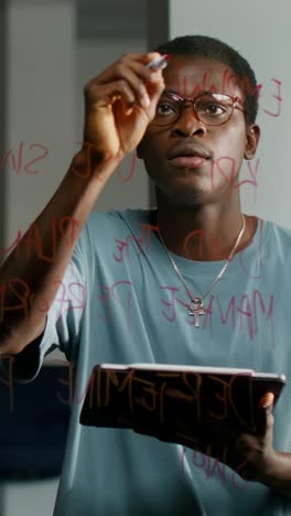 man taking notes on a glass board