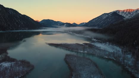 Malerisches-Gebirgsflusstal-Mit-Frischem-Wasser-In-Den-Bayerischen-österreichischen-Alpen-Am-Sylvensteinspeicher-Bei-Sonnenuntergang,-Winterschneeflussbett-Entlang-Bäumen-Und-Wald-Und-Bergen