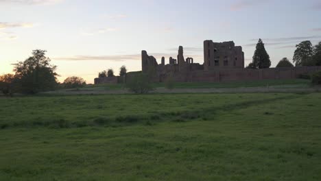 Toma-Panorámica-Que-Muestra-El-Castillo-De-Kenilworth-En-La-Puesta-De-Sol-De-Finales-De-Verano,-Vista-A-Través-De-Un-Prado,-Warwickshire,-Inglaterra