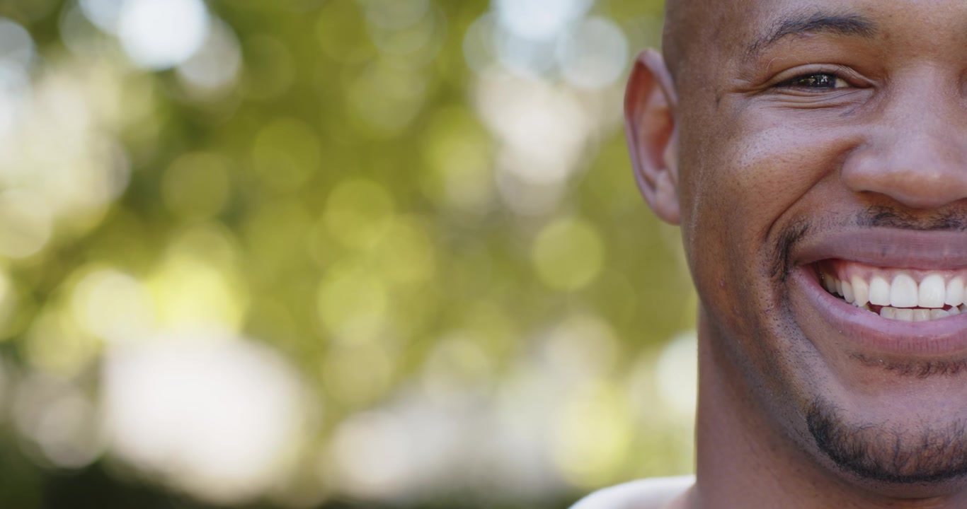 Man showing smile slowly starting in sunlit park, animated emotion graph tracking change for tech
