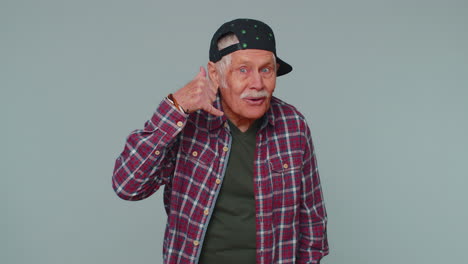 cheerful senior man in shirt looking at camera doing phone gesture like says hey you call me back