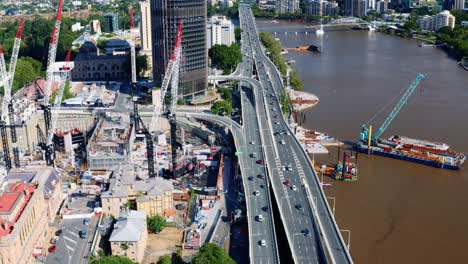 vehículos que viajan en la autopista riverside pasando por la construcción del muelle de la reina y el gobierno de queensland en brisbane, australia