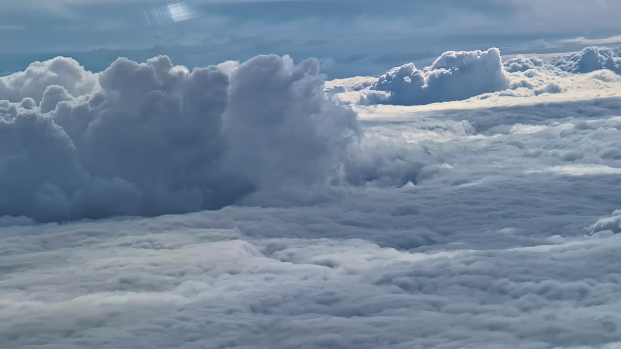 Flight high altitude over layer of clouds travelling plane window point of view