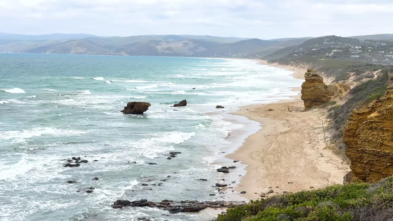 Aerial view of rugged coastline with cliffs and ocean waves under soft daylight, showcasing natural beauty and tranquility