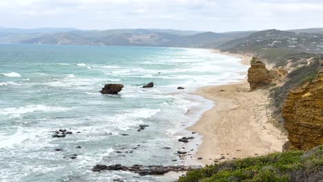 aerial view of rugged coastline with cliffs and ocean waves under soft daylight, showcasing natural beauty and tranquility
