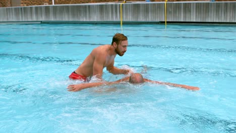 Rettungsschwimmer-Rettet-älteren-Mann-Aus-Schwimmbad